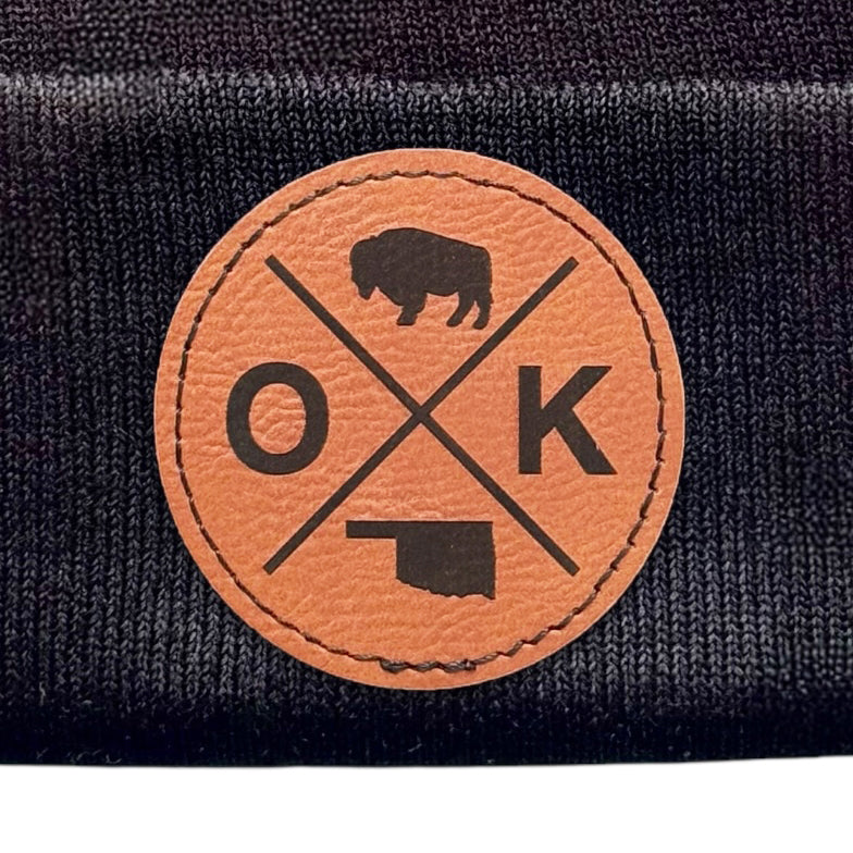 Black OK X beanie showcasing the OK X design patch in a close-up view.