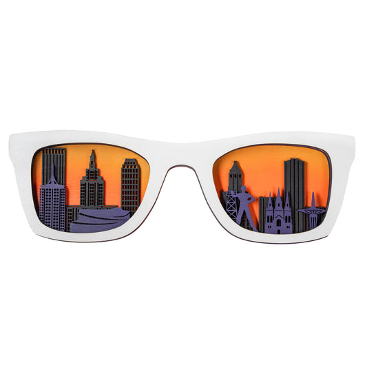 White-framed wooden layered glasses showcasing Tulsa’s skyline in purple and orange hues.