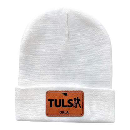 White knit beanie showcasing a leather patch with the Tulsa Driller design, perfect for winter wear with Oklahoma pride.